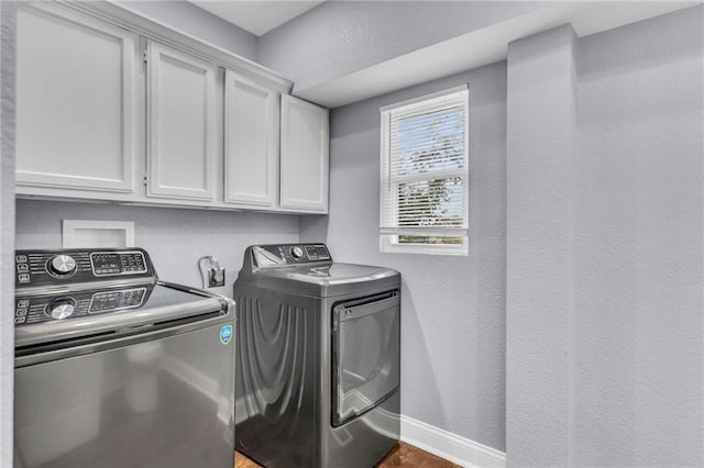 laundry room with washer and dryer and cabinets