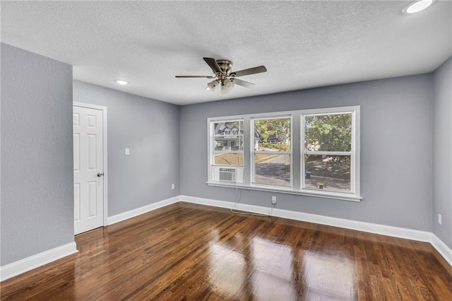 spare room with ceiling fan, cooling unit, a textured ceiling, and dark wood-type flooring