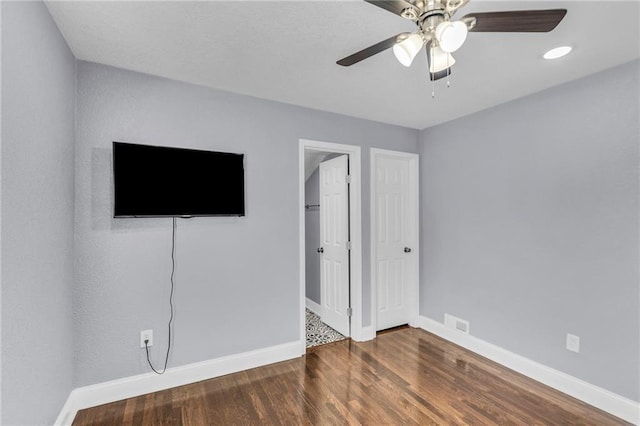 unfurnished bedroom featuring dark hardwood / wood-style flooring and ceiling fan