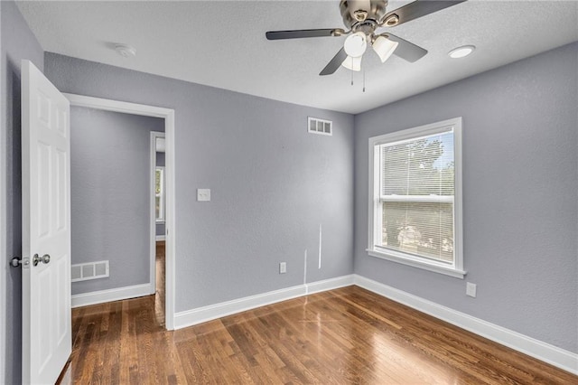 spare room featuring ceiling fan and dark wood-type flooring