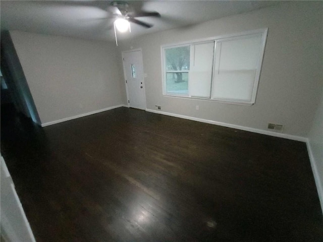 spare room with dark hardwood / wood-style floors and ceiling fan