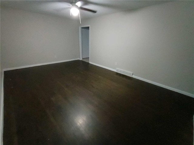 6914 Rowland Ave, Kansas City, KS 66109 - spare room with dark wood-type flooring, visible vents, baseboards, and a ceiling fan