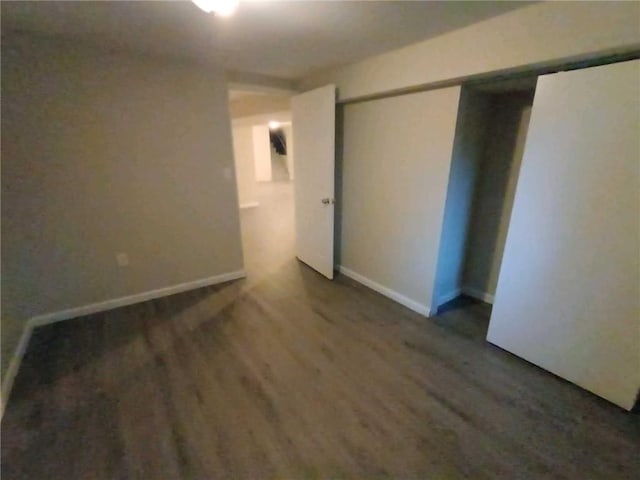 unfurnished bedroom featuring a closet and dark hardwood / wood-style floors