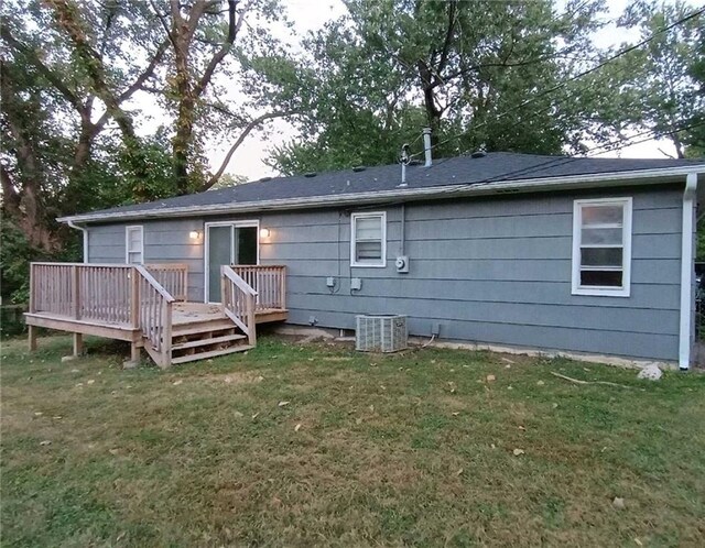 back of property with a deck, a yard, and central AC unit