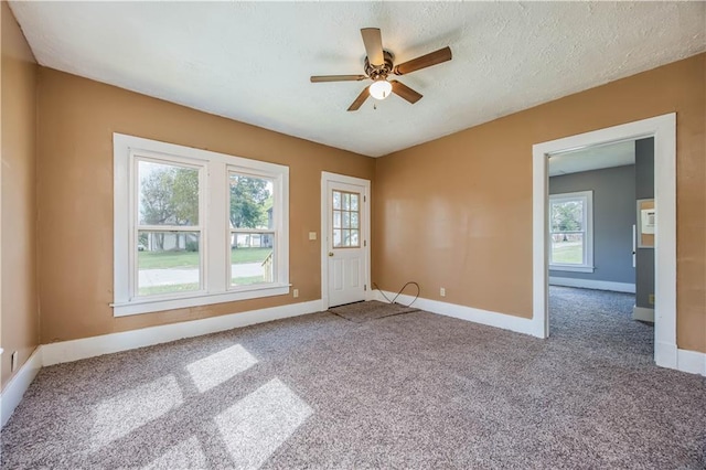 carpeted spare room featuring ceiling fan and a textured ceiling