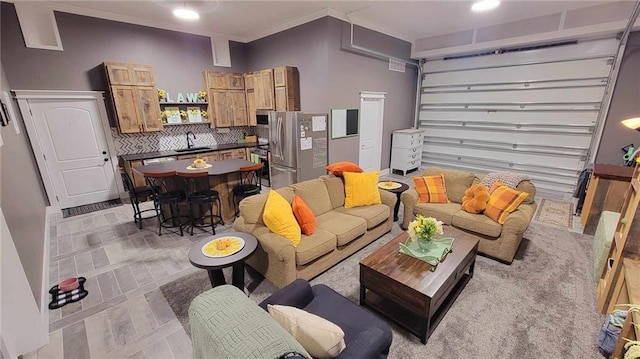 living room featuring sink and crown molding