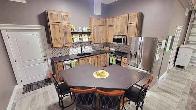 kitchen featuring decorative backsplash, stainless steel appliances, light hardwood / wood-style flooring, and sink