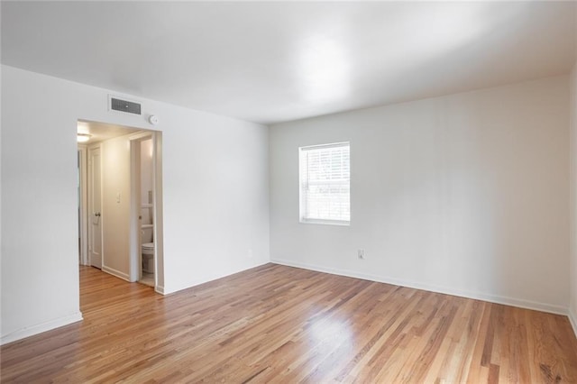 spare room featuring light wood finished floors and baseboards