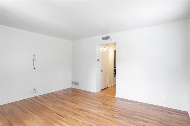 spare room featuring light wood-type flooring and baseboards