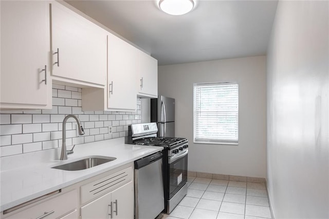 kitchen featuring light tile patterned flooring, tasteful backsplash, sink, white cabinets, and stainless steel appliances