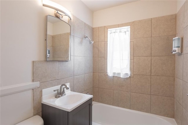 full bathroom with tiled shower / bath combo, vanity, and toilet