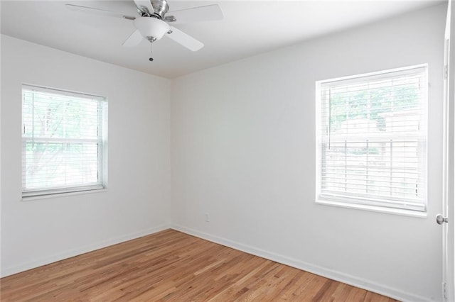 spare room featuring plenty of natural light, light wood finished floors, baseboards, and ceiling fan