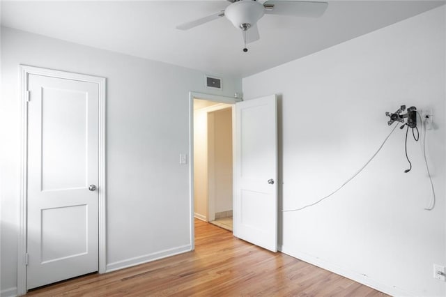 unfurnished bedroom featuring light wood-style floors, baseboards, and a ceiling fan