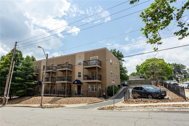 view of apartment building / complex featuring fence