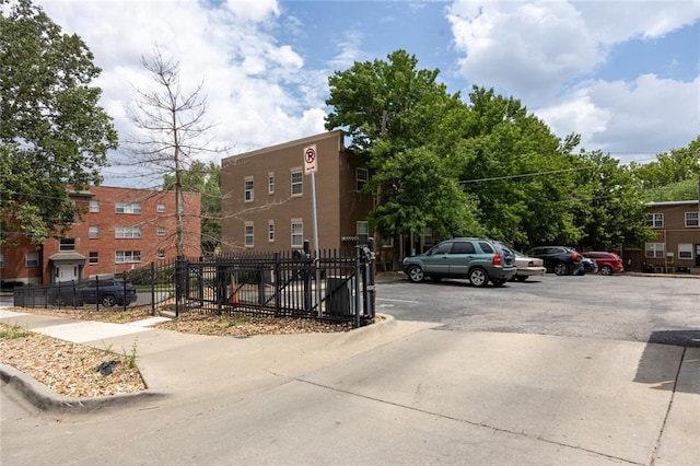 view of property featuring uncovered parking and fence