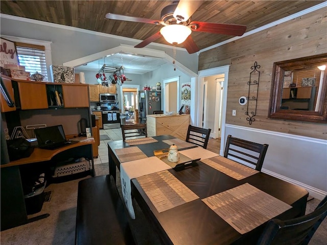 tiled dining space featuring ceiling fan, wood walls, crown molding, and wooden ceiling