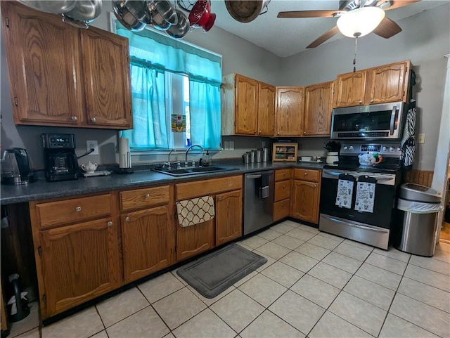 kitchen featuring appliances with stainless steel finishes, light tile patterned floors, sink, and ceiling fan