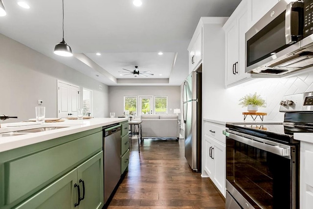 kitchen with white cabinets, green cabinets, ceiling fan, light countertops, and appliances with stainless steel finishes