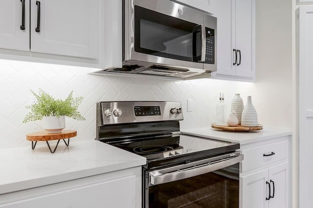kitchen featuring backsplash, appliances with stainless steel finishes, light stone counters, and white cabinetry