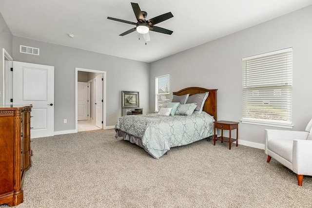 bedroom with baseboards, light carpet, visible vents, and a ceiling fan