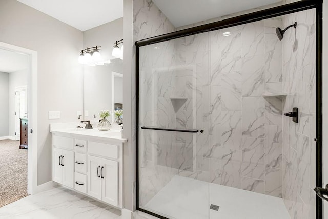 full bath featuring a sink, a marble finish shower, marble finish floor, double vanity, and baseboards
