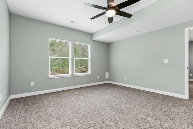 empty room with visible vents, carpet flooring, baseboards, and ceiling fan