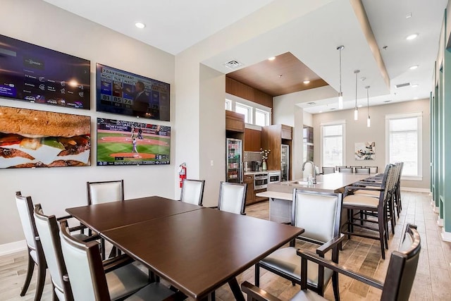 dining room featuring light wood-type flooring, baseboards, recessed lighting, and visible vents