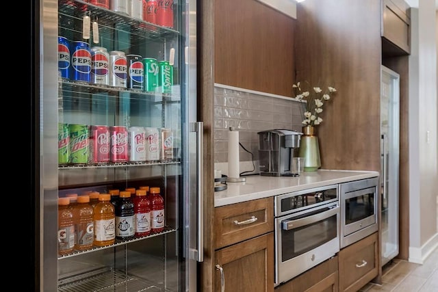 kitchen with brown cabinetry, light countertops, and appliances with stainless steel finishes