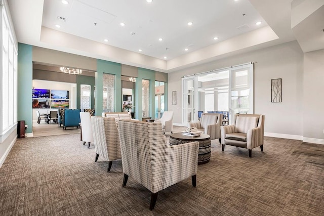 carpeted living area featuring visible vents, baseboards, a tray ceiling, and recessed lighting