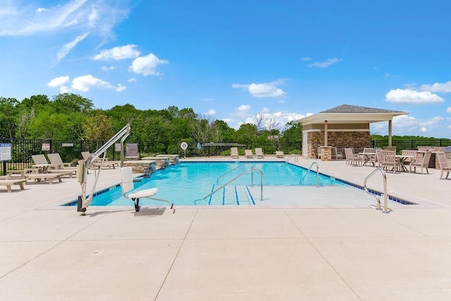 community pool with fence and a patio area