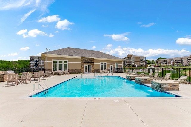 pool featuring a jacuzzi, fence, and a patio area