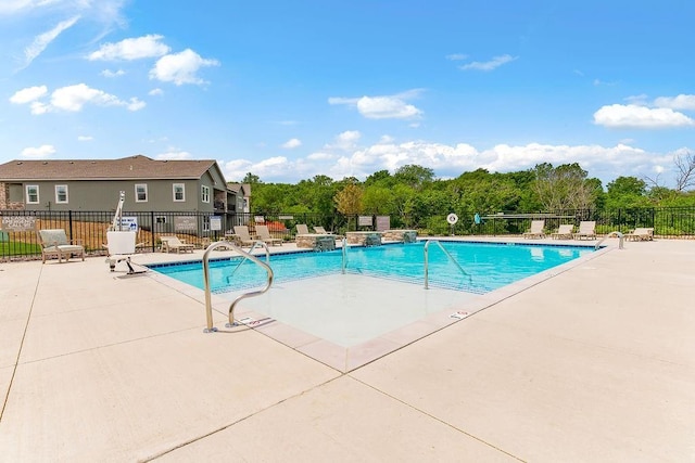 community pool with a patio and fence