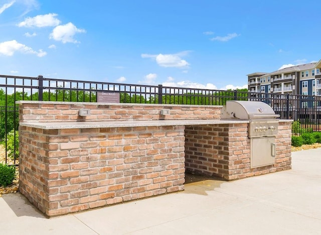 view of patio with fence, an outdoor kitchen, and area for grilling