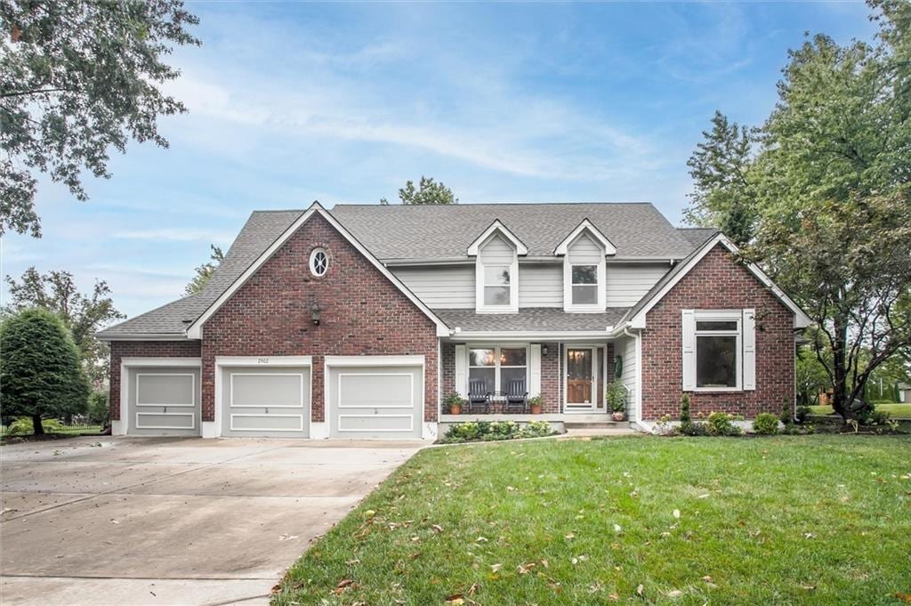 view of front of house featuring a front lawn, a porch, and a garage