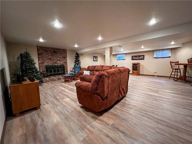 living room with a brick fireplace and hardwood / wood-style flooring