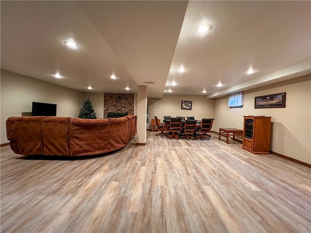 living room with light wood-type flooring and a brick fireplace