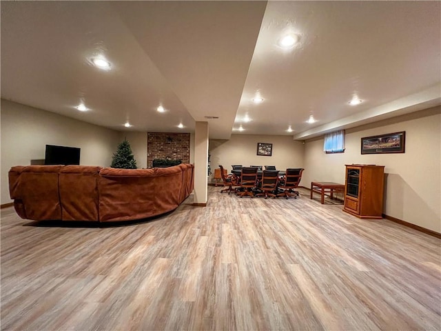 living room featuring light wood finished floors, baseboards, recessed lighting, and a brick fireplace