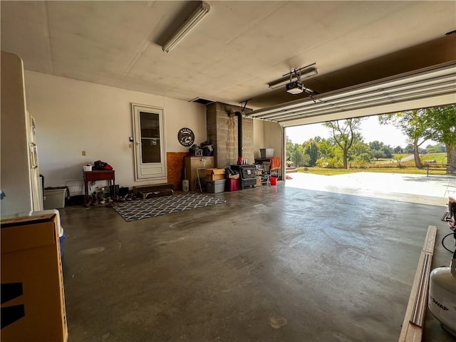 garage with a garage door opener and a wood stove