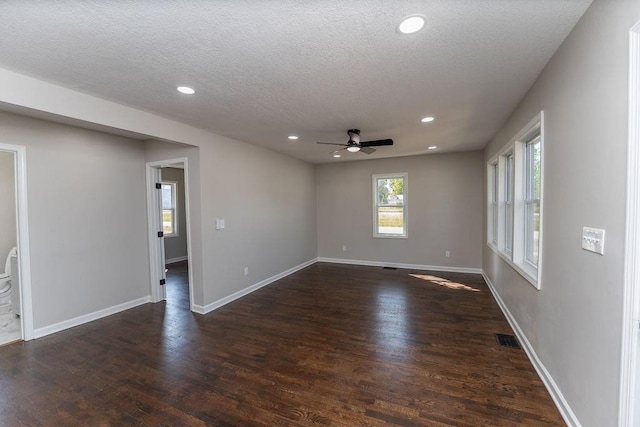 unfurnished room with ceiling fan, a textured ceiling, and dark hardwood / wood-style floors