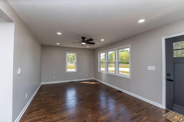 empty room featuring a textured ceiling, dark hardwood / wood-style flooring, and ceiling fan