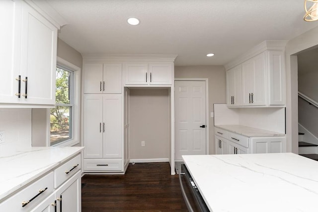 kitchen with light stone counters, white cabinets, backsplash, dishwasher, and dark hardwood / wood-style floors