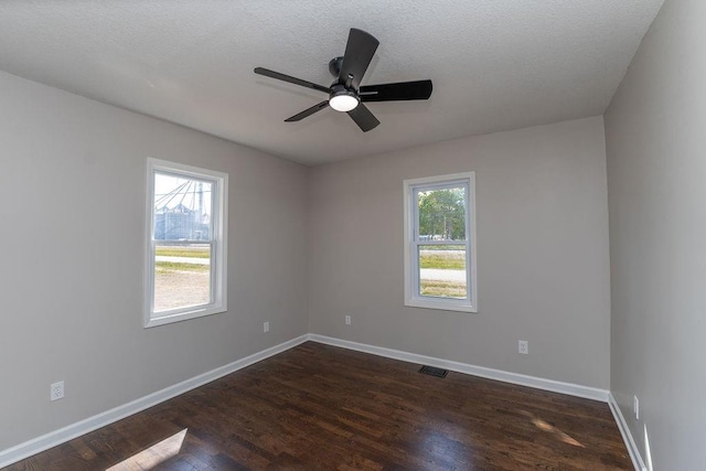 unfurnished room with ceiling fan, dark hardwood / wood-style flooring, and a healthy amount of sunlight