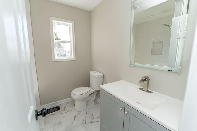 bathroom with walk in shower, vanity, and toilet