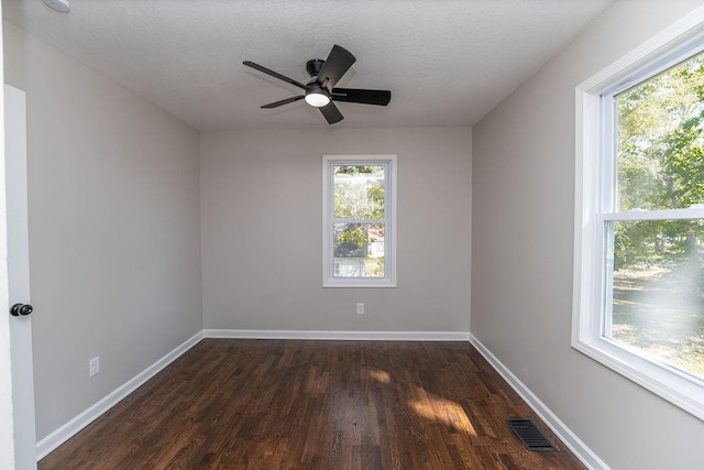 empty room featuring a textured ceiling, dark wood-type flooring, and ceiling fan