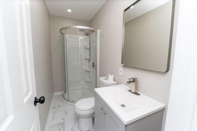 bathroom featuring a shower with shower door, vanity, and toilet