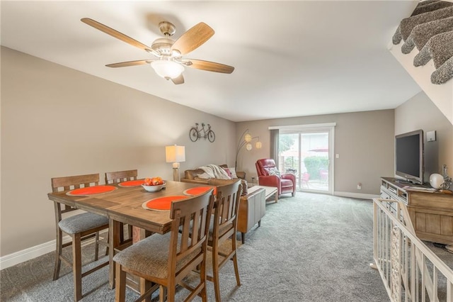 carpeted dining area with ceiling fan