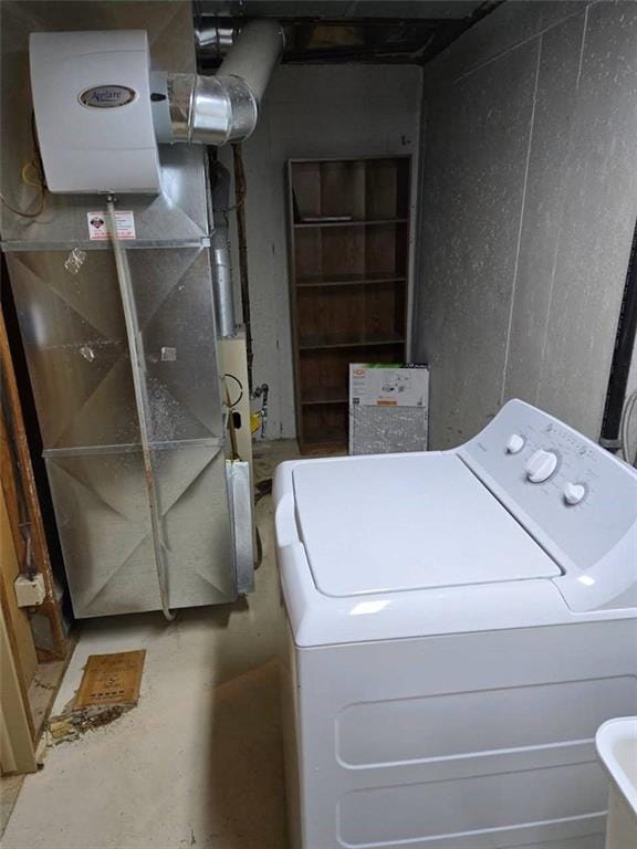 washroom featuring heating unit, laundry area, and washer / clothes dryer