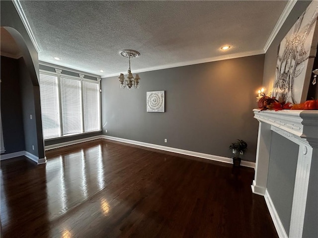 interior space featuring a textured ceiling, ornamental molding, dark hardwood / wood-style flooring, and an inviting chandelier