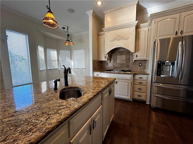 kitchen with dark stone countertops, decorative light fixtures, appliances with stainless steel finishes, and sink