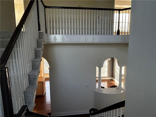 stairs featuring wood-type flooring and ornate columns